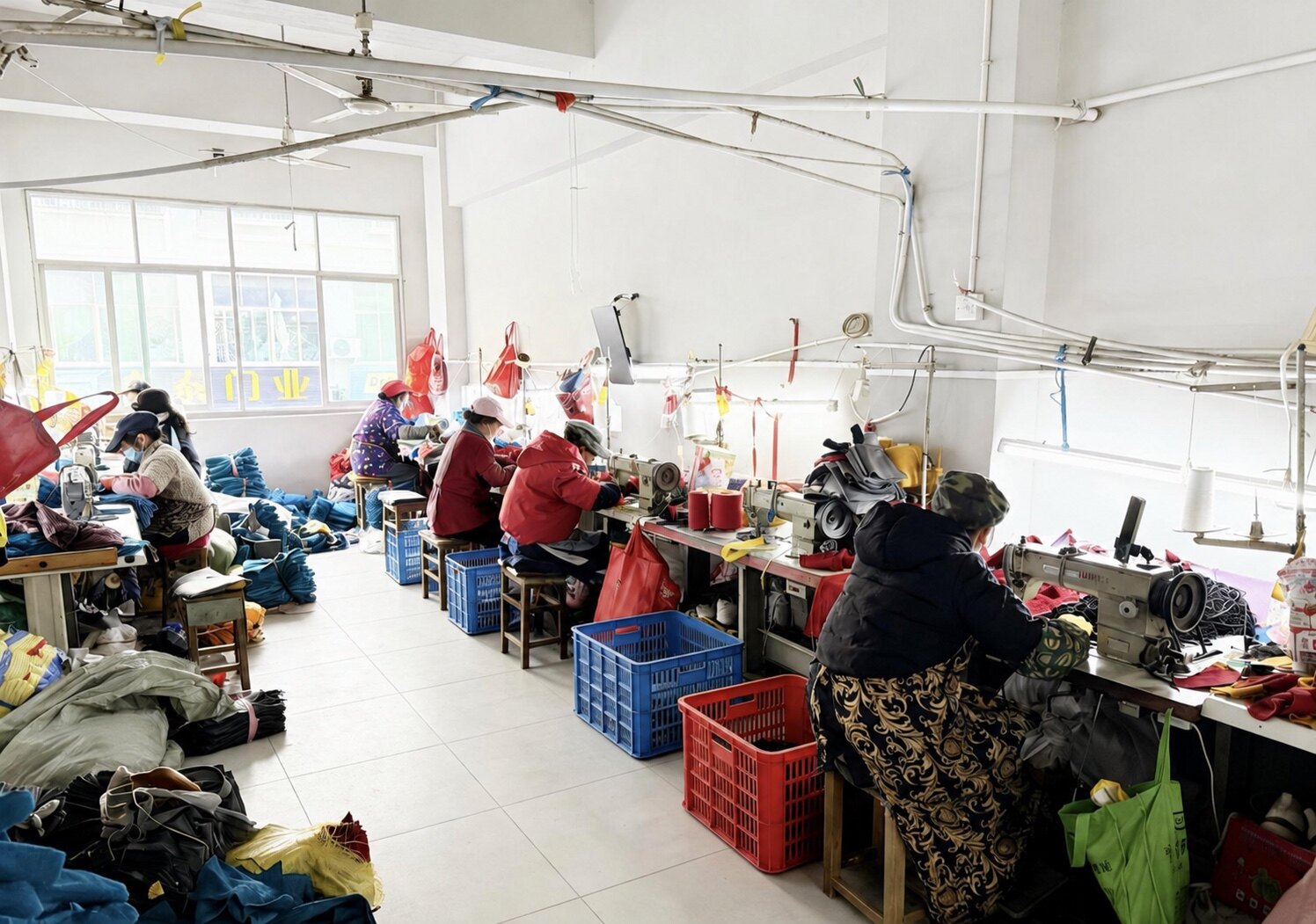 Workers stitching protective gloves on an active production line